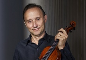Dene Olding, wearing a black collared shirt and holding a violin