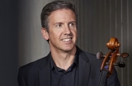 Image of Julian Smiles, smiling and holding his cello